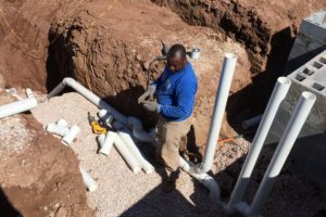 doing pvc plumbing work in a large trench