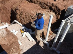 doing pvc plumbing work in a large trench